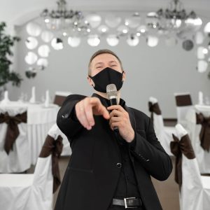 showman-in-a-suit-and-protective-mask-with-a-micro-2026-01-07-02-29-21-utc.jpg